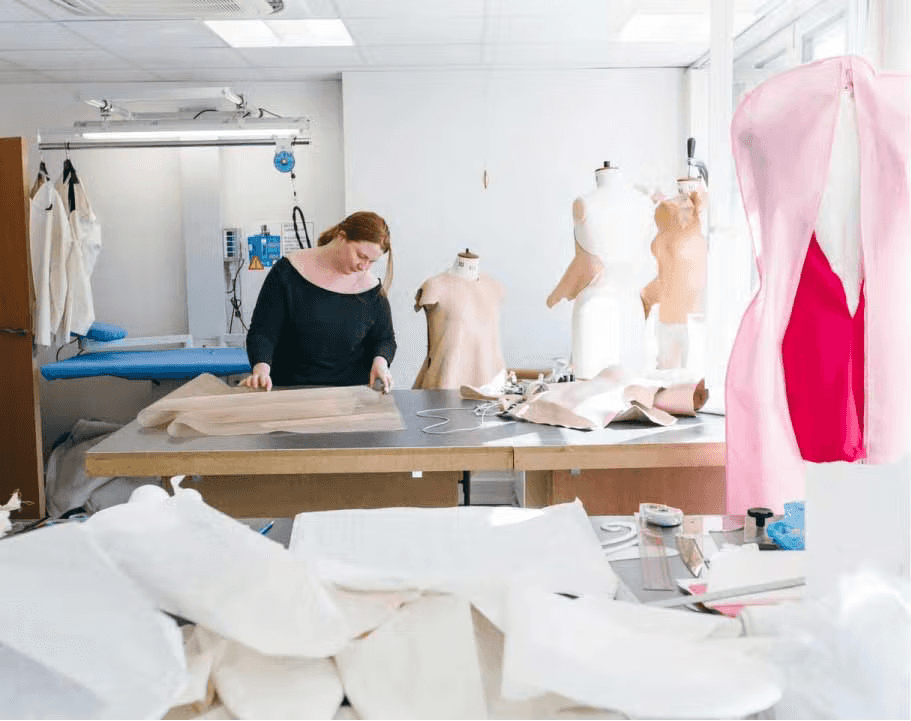 Woman working at a worktable creating a new fashion collection